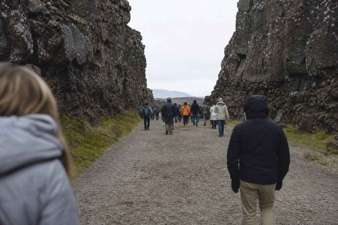 Walkers on the path through the Almannagjá rift at Þingvellir under flat overcast light