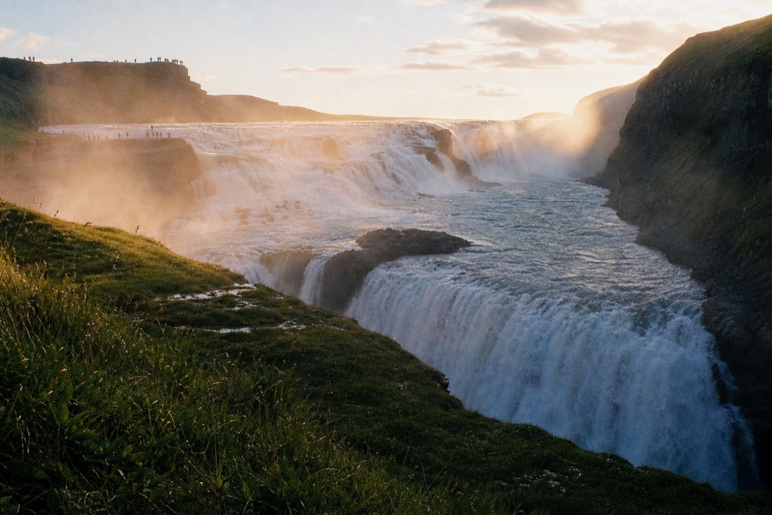 Gullfoss dropping in two tiers into its gorge with spray rising in low golden evening light