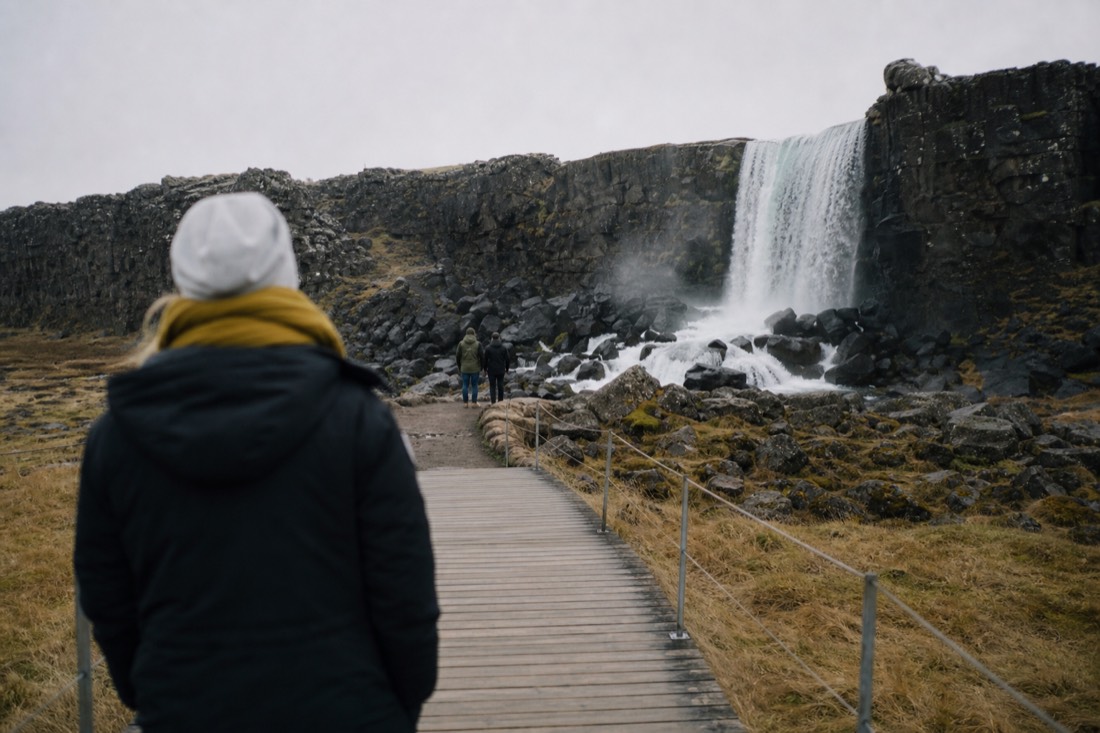 Boardwalk leading toward Öxarárfoss waterfall inside the Þingvellir rift on an overcast day