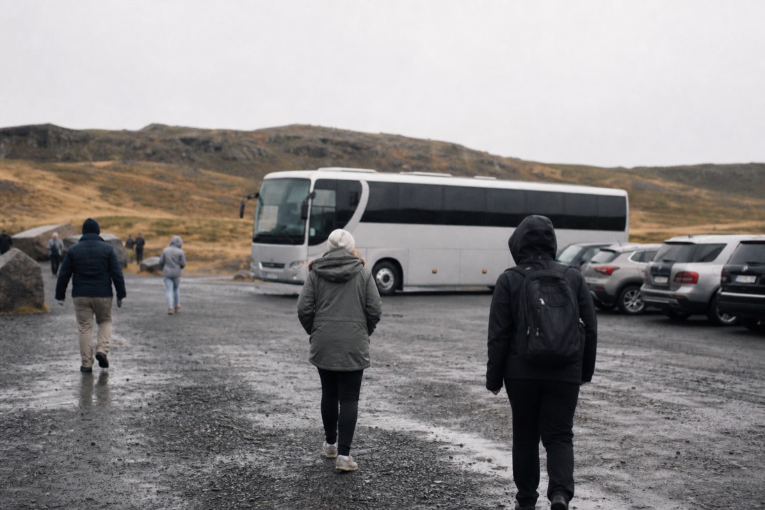 Small tour bus in the Gullfoss car park as visitors walk back from the falls