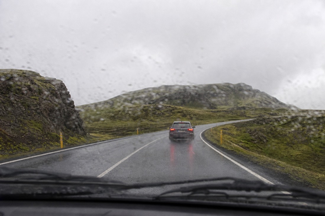 A small hatchback on the wet two-lane blacktop of Route 35 in light drizzle